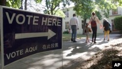 FILE - Voters walk to a precinct place at the Sierra 2 Center for the Arts and Community to cast their ballots, June 5, 2018, in Sacramento, California. 