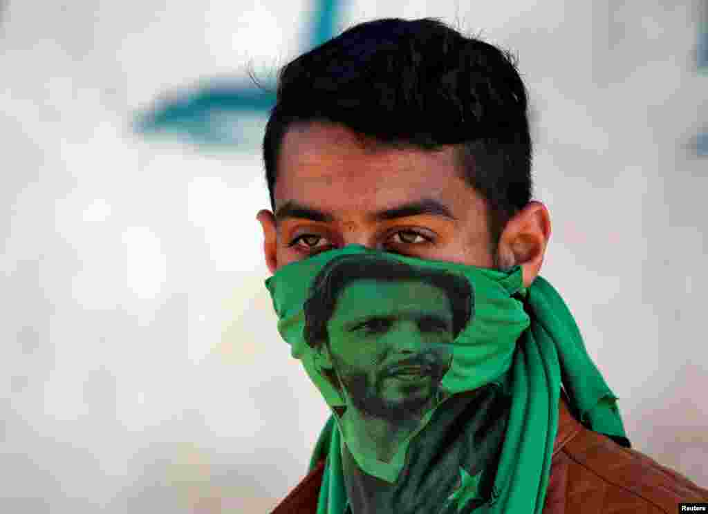 A protester wearing a mask with an image of former Pakistani cricket player Shahid Afridi attends a protest against the recent killings in Kashmir, in Srinagar April 12, 2018.