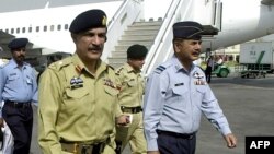 FILE - Lt. General Shahid Aziz (foreground, left) walks with military officials at Allama Iqbal International Airport in Lahore, Pakistan, March 25, 2004.