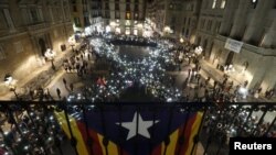 Para peserta aksi demo dari asosiasi pro-kemerdekaan, menyerukan pembebasan bagi para aktivis dan pemimpin Catalan yang dipenjarakan, dengan membentuk formasi pita di alun-alun Sant Jaume, Barcelona, Spanyol, 16 November 2017.