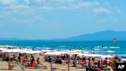 People enjoy a sunny day on the beach in Tuscany's Castiglione della Pescaia, Italy, May 24, 2020.