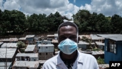 A staff member of local NGO Shining Hope for Communities wears a face mask as a preventive measure against the COVID-19 coronavirus as the NGO installs hand-washing stations at the Kibera slum in Nairobi, March 18, 2020. 