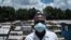 A staff member of local NGO Shining Hope for Communities wears a face mask as a preventive measure against the COVID-19 coronavirus as the NGO installs hand-washing stations at the Kibera slum in Nairobi, March 18, 2020. 