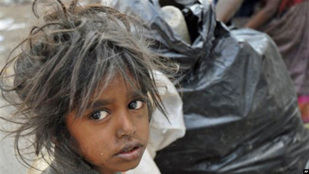 A child sits in front of a garbage dump on World Poverty Day in Hyderabad, India, 17 October 2007 (FILE).