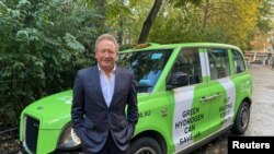 Miliarder asal Australia Andrew Forrest berpose di depan sebuah taksi dalam sebuah kampanye mempromosikan penggunaan energi hidrogen bersih sebagai energi alternatif di London, Inggris, pada 25 Oktober 2021. (Foto: Reuters/Ben Makori)