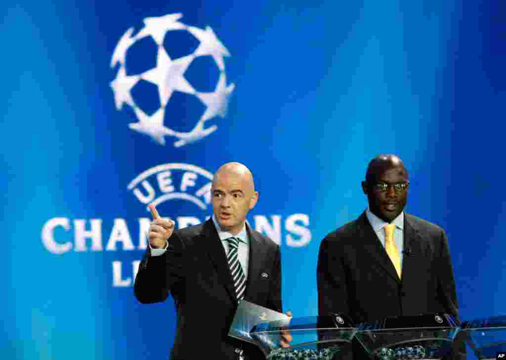 Le secrétaire général de l&rsquo;UEFA Gianni Infantino à gauche fait geste alors que l&rsquo;ancien footballeur libérien George Weah le regarde lors du tirage de la Champions League de l&rsquo;UEFA à au forum Grimaldi, à Monaco, jeudi, le 30 aout 2014. Weah a annoncé sa candidat aux prochaines élections pour le Sénat après au Liberia.