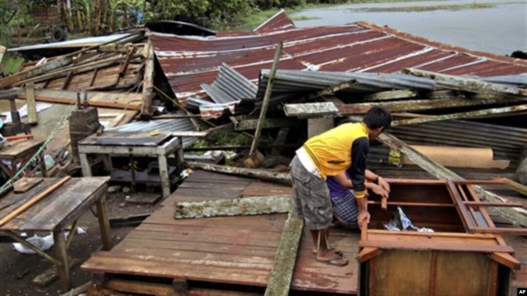 Seorang warga Filipina berdiri di atas puing-puing rumahnya yang hancur akibat hantaman topan Bopha yang melanda negeri itu (Foto: dok).