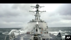 FILE - Sea spray whips across deck of USS Winston Churchill guided missile destroyer (DDG 81).