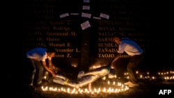 FILE - People lift a mock victim during a prayer vigil in support of the families of victims of extra-judicial killings in Manila on April 12, 2017.