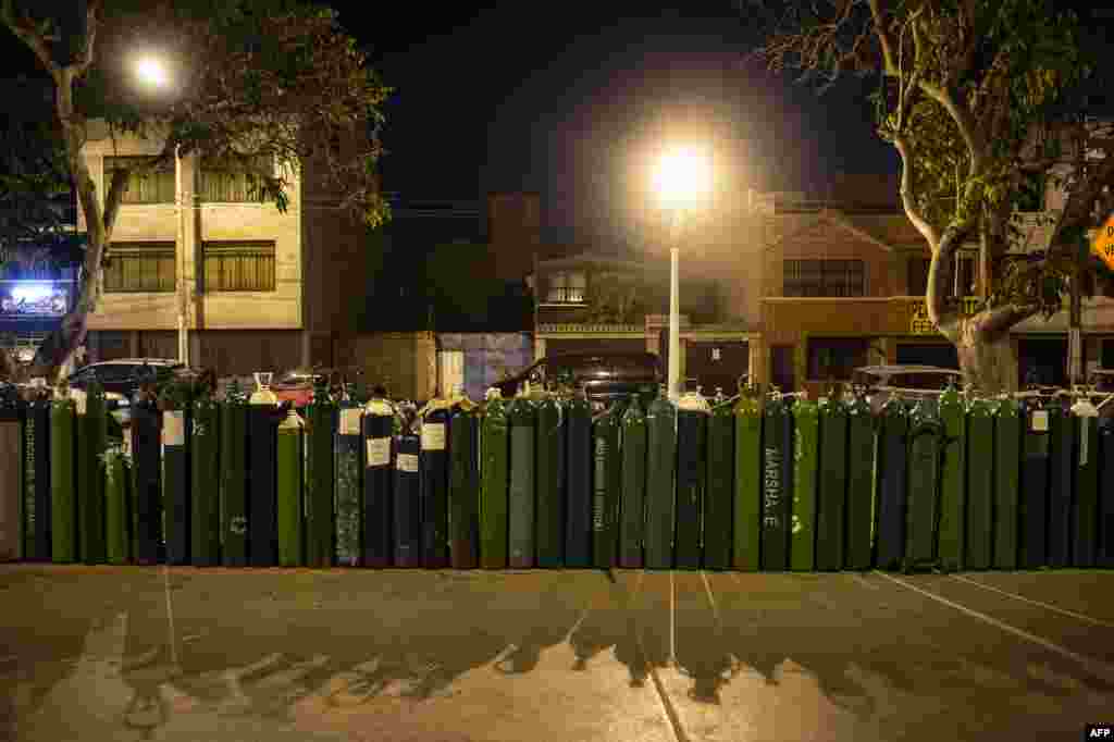 People queue to refill their empty oxygen cylinders in Callao, Peru, amid the COVID-19 pandemic. Relatives of people with COVID-19 are desperate for oxygen to keep their loves ones alive in Peru, where patients have been dying for lack of oxygen.