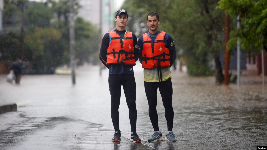 Los remeros preolímpicos brasileños Evaldo Mathias Becker y Piedro Tuchtenhagen posan para una fotografía mientras ayudan a rescatar a las víctimas de las inundaciones en Porto Alegre, estado de Rio Grande do Sul, Brasil, 10 de mayo de 2024.