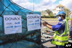 FILE - A worker handles boxes of COVID-19 vaccines, delivered as part of the COVAX equitable vaccince distribution program, at Ivato International Airport, in Antananarivo, Madagascar, May 8, 2021.