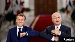 French President Emmanuel Macron and Iraq's President Barham Salihat greet each other with an elbow bump as they attend a news conference in Baghdad, Iraq, Sept. 2, 2020. 