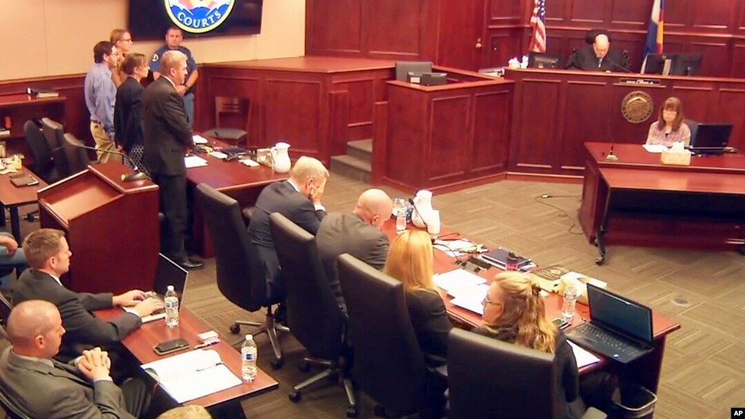 In this image taken from video, accused Colorado theater shooter James Holmes, standing on the far left, listens as the verdict is read during his trial, in Centennial, Colorado, July 16, 2015. 