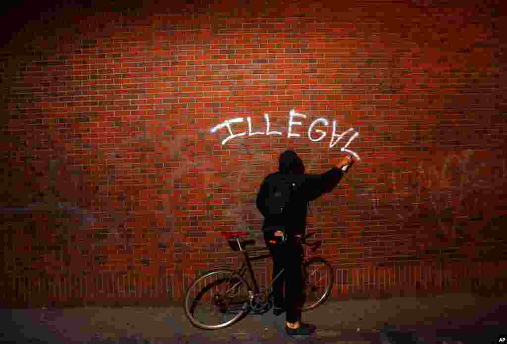 October 26: An Occupy Oakland protester spraypaints during a march in Oakland, Calif. (AP Photo/Noah Berger)