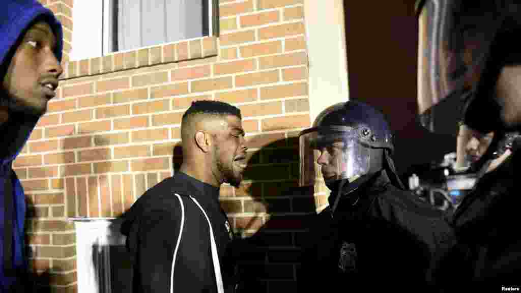 Demonstrators confront law enforcement officers near Baltimore Police Department Western District to protest against the death of Freddie Gray in police custody, in Baltimore, April 25, 2015. 