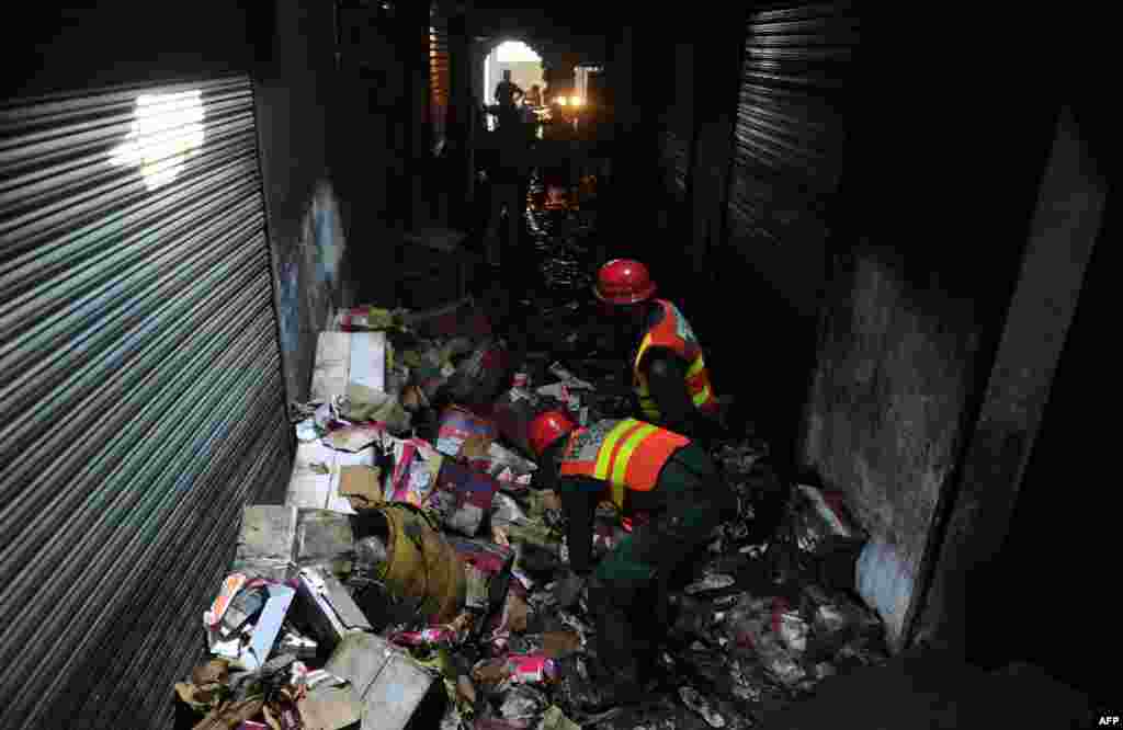 Pakistani rescuers collect evidence in a shoe-making factory following a fire which gutted the factory the previous night in Lahore, September 12, 2012.