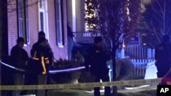 In this still frame from video provided by WCAX-TV law enforcement officers stand by police tape near a scene Saturday, November. 25, 2023 where three men of Palestinian descent were shot and injured, in Burlington, Vermont. 