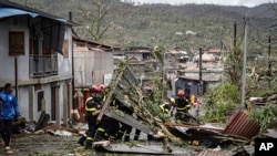 Fotografía dl lunes 16 de diciembre de 2024 muestra a los rescatistas despejando una calle en el territorio francés de Mayotte, en el océano Índico, después de que la isla fuera azotada por su peor ciclón en casi un siglo.