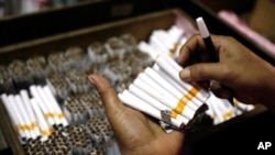 An employee counts cigarettes before packing them in Sidoarjo, Indonesia's East Java province April 7, 2010. 