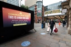 FILE - Public information messages are posted in Manchester, England, after British Prime Minister Boris Johnson issued new restrictions to slow the renewed spread of the coronavirus, Sept 22, 2020.