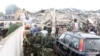 People look at an excavator clearing the rubble on the scene of a six-story shopping center that collapsed in Accra, November 7, 2012.