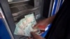 Un hombre cuenta billetes de bolívares -la moneda venezolana- que sacó de un cajero automático en Caracas, el 21 de agosto de 2018.