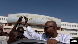 Le député socialiste sénégalais et membre de la coalition au pouvoir, Barthélemy Dias, salue les sympathisants alors qu'il quitte le palais de justice de Dakar le 1er décembre 2016.