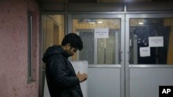 A man checks his cellphone outside a media facilitation center in Srinagar, Indian-controlled Kashmir, after authorities announced text messaging are being restored, Dec. 31, 2019.