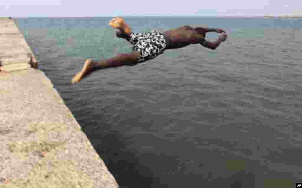 A boy jumps into the Atlantic Ocean at the beach in Bata January 27, 2012. REUTERS/Amr Abdallah Dalsh (EQUATORIAL GUINEA - Tags: SOCIETY TRAVEL)