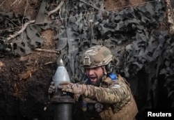 Seorang prajurit Ukraina menembakkan mortir ke arah pasukan Rusia di garis depan dekat Kota Bakhmut. (Foto: Reuters)