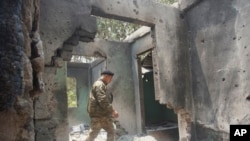 FILE - Saw Win Myint, a commander of a military unit under the Karen National Union, the leading political body for the Karen ethnic minority that is part of the resistance against military rule in Myanmar, inspects the damaged armory in the captured army base of Infantry Battalion 275 in Myawaddy township in Kayin state, Myanmar, on April 12, 2024.. (AP Photo/Metro, File)