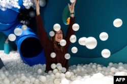 Museum founder Andrea Golubic poses inside a pool full of small white balls at the HaHaHouse museum of laughter in central Zagreb, on January 21, 2025. (Photo by Damir SENCAR / AFP)