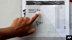 FILE - A migrant in Matamoros, Mexico checks a typewritten list of more than 800 people seeking asylum in the US, April 30, 2019. Those marked with the word "rio," Spanish for river, are believed to have crossed the Rio Grande to enter the US without authorization.