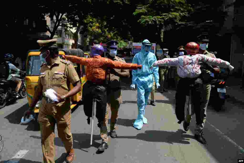 Policemen hold effigys of demons representing COVID-19 during an awareness campaign along a street in Chennai, as India surged past 13 million coronavirus cases.