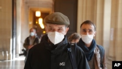 Josu Urrutikoetxea, the last-known chief of ETA, followed by his son Egoitz Urrutikoetxea, arrives at the Palace of Justice, Paris, as he goes on trial for terrorism charges, Oct. 19, 2020.