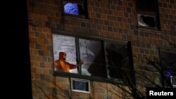 Seseorang berdiri di dalam gedung apartemen tempat kebakaran terjadi di wilayah Bronx, New York City, AS, 9 Januari 2022. (Foto: REUTERS/Andrew Kelly)