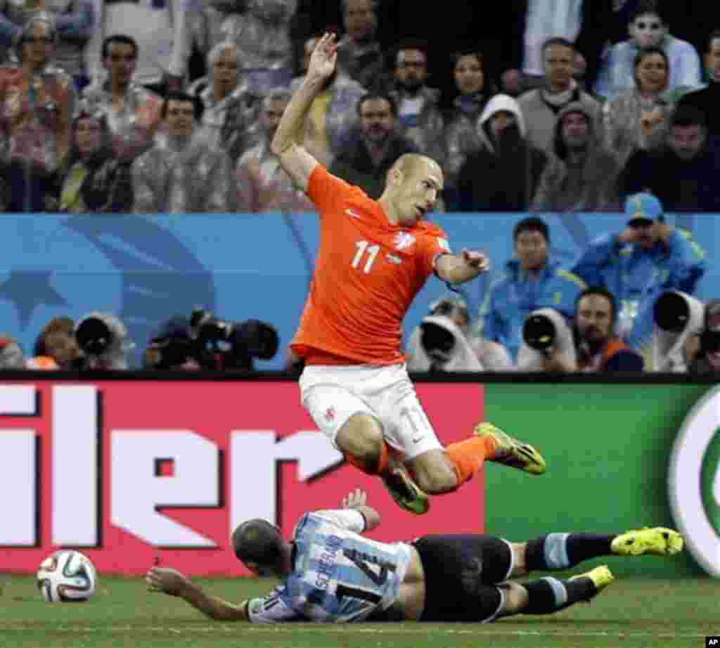 Netherlands' Arjen Robben (11) leaps over Argentina's Javier Mascherano (14) during the World Cup semifinal soccer match between the Netherlands and Argentina at the Itaquerao Stadium in Sao Paulo Brazil, Wednesday, July 9, 2014. (AP Photo/Natacha Pisaren