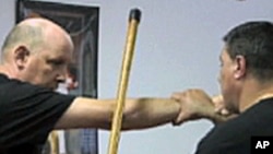 埃尔南德斯(右)向学员示范拐杖功招式