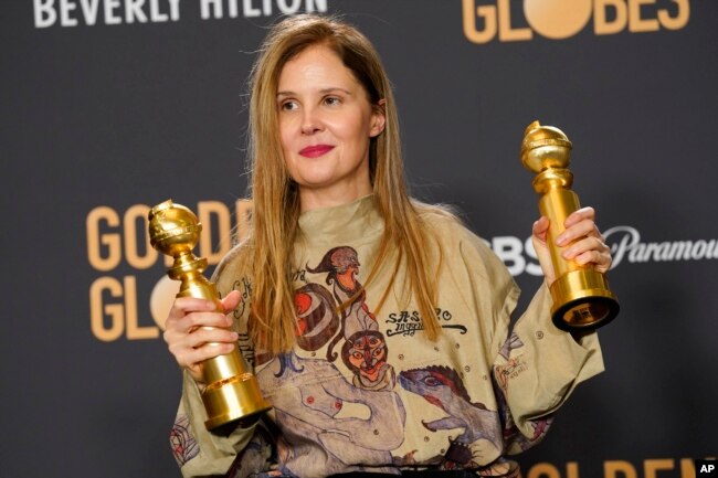 Justine Triet poses with the awards for best screenplay, motion picture for "Anatomy of a Fall" and for best motion picture, foreign language, at the 81st Golden Globe Awards January 7, 2024 in Beverly Hills, California. (AP Photo/Chris Pizzello)