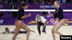 Kerri Walsh Jennings (R) and Misty May-Treanor of the US celebrate a point against Australia during women's beach volleyball match at 2012 Olympics