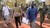 A Friday, Jan. 16, 2015 photo released by the Uganda People's Defence Force (UPDF), shows a man said by the UPDF to be the wanted Lord's Resistance Army (LRA) commander Dominic Ongwen, center-right, is handed over by the UPDF to the African Union Regional Task Force who later handed him over to Central African Republic authorities, in the Central African Republic, Jan. 16, 2015. 