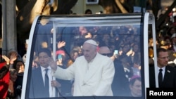 Pope Francis waves to the crowd as he leaves the capital en route to Ciudad Juarez, the last stop of his visit to Mexico, in Mexico City, February 17, 2016. 