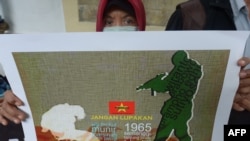 Seorang demonstran menunjukkan poster penculikan aktivis pada 1997-1998 dalam unjuk rasa memprotes pencalonan Prabowo Subianto dalam pilpres 2014, 20 Mei 2014. (Foto: AFP)