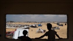 Anak-anak Palestina mengamati kamp untuk pengungsi di Rafah, bagian selatan Jalur Gaza yang berbatasan dengan Mesir di tengah perang antara Israel dan kelompok Hamas Palestina, 28 April 2024. (Foto: AFP)