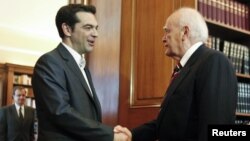 El líder izquierdista Alexis Tsipras (izquierda) saluda al presidente griego Karolos Papoulias, quien le ha pedido intentar formar un nuevo gobierno.