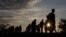Migrants walk along rail tracks as they arrive at a collection point in the village of Roszke, Hungary, Sept. 8, 2015, after crossing the border from Serbia.
