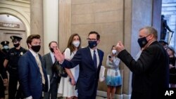 FILE - Treasury Secretary Steven Mnuchin, third from left, and White House Legislative Affairs Director Eric Ueland, left, walk to a meeting with Senate Minority Leader Sen. Chuck Schumer in his office on Capitol Hill, March 23, 2020, in Washington.