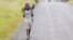 A boy carries a goat along a road near the town of Sake, about 27 kilometers west of Goma, DRC, November 27, 2012.