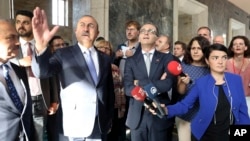 Turkey's Foreign Minister Mevlut Cavusoglu (2nd-L) talks to German Foreign Minister Heiko Mass (C-R) during a visit to a section of the Turkish parliament, damaged during the failed July 15, 2016 coup attempt, in Ankara, Turkey, Sept. 5, 2018. 